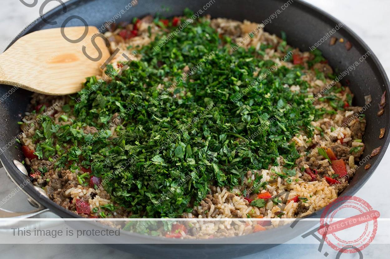 Agregue perejil y cilantro a la carne y al arroz chimichurri después de cocinar.